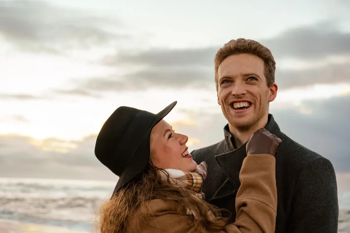 a woman looking up and laughing at her lover's jokes during their photoshoot near Amsterdam