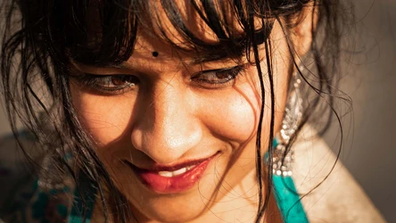 a closeup of a young indian woman with perfect skin, smile and hair