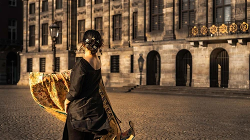 an indian woman dancing in her traditional scarf on Dam Square Amsterdam