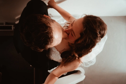 Top down view of couple kissing in black and white wedding attire, captured by DiscussTomorrow